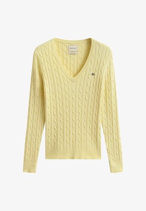 Geel kabelgebreide V-hals trui met lange mouwen en een klein geborduurd logo op de linkerborst.