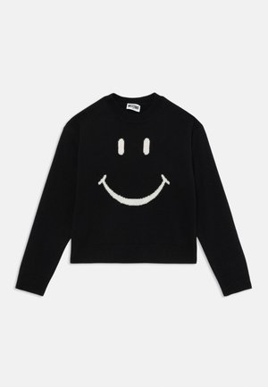 Svart kort kardigan i stickad kvalitet med ett stort vitt smiley-ansikte på framsidan. Ribbad detaljer vid ärmslut och halsringning.