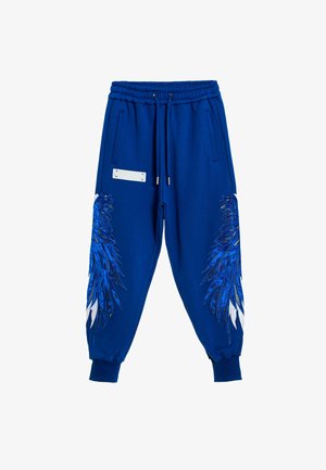Pantalones de chándal azules de algodón con un detallado bordado en azul y blanco de alas a los lados y una cinturilla con cordón.
