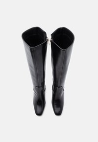 Μαύρες δερμάτινες μπότες μέχρι το γόνατο με κομψό φινίρισμα, τετράγωνη μύτη και διπλούς φερμουάρ στις πλευρές για εύκολη χρήση.