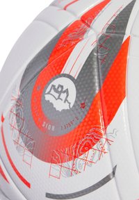 White soccer ball with red and gray accents. Features a textured surface, geometric patterns, and a central logo with coordinates.