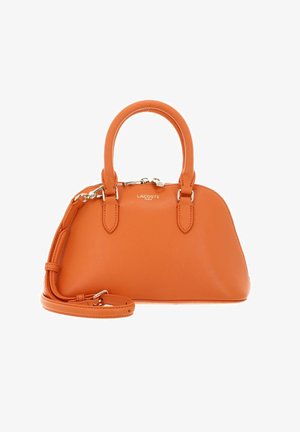 Sac à main en cuir orange avec deux poignées, une bandoulière amovible, une fermeture éclair argentée et un logo Lacoste Paris sur le devant.