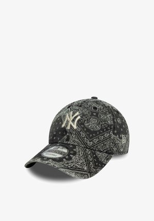 Gorra de béisbol ajustable con patrón de bandana en blanco y negro y logo de los New York Yankees en beige en la parte frontal.