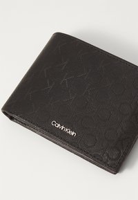 Portafoglio nero con un motivo testurizzato e logo impresso. Realizzato in materiale sintetico con un design ripiegato e cuciture visibili.