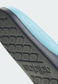 Suela Cloudfoam en negro y azul claro, con una superficie texturizada que presenta un patrón hexagonal y la marca "CLOUDFOAM" en relieve.