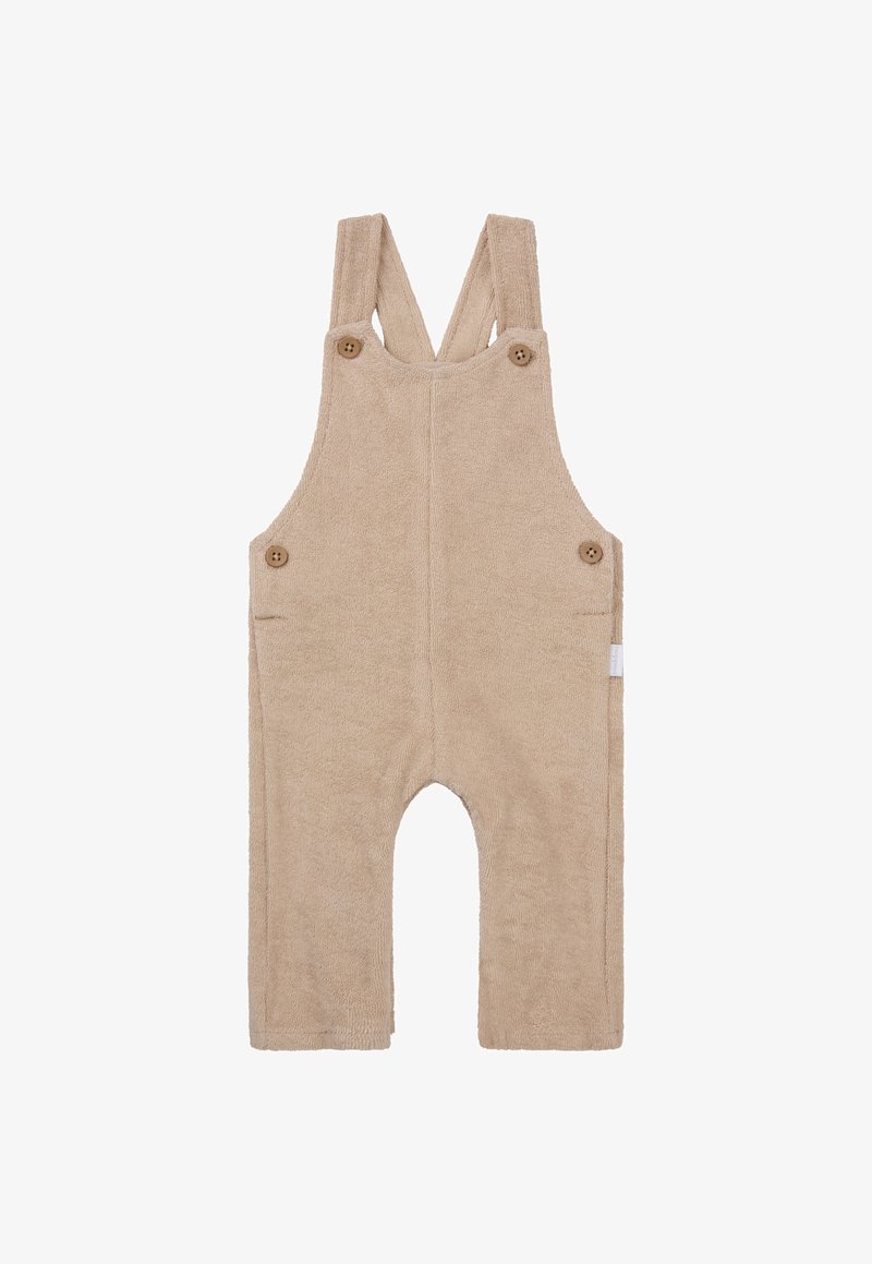 Beige Frottee-Latzhose mit verstellbaren Trägern, Holzknöpfen, zwei seitlichen Taschen und runden Ausschnitten für die Beine.