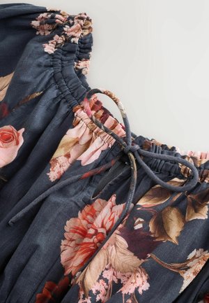 Floral fabric blouse with a dark blue background, featuring pink and rose patterns, an elastic neckline, and a drawstring accent.
