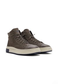 Bruine leren hoge schoenen met een gestructureerd oppervlak, contrasterende beige zool en donkerblauw accent. Kenmerkt veters en een logo-detail.