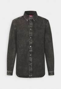 Svart denimskjorta med nedknäppt krage, långa ärmar och en subtil logo. Har en något blekt yta och metallknappar.