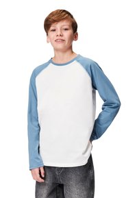 Valkoinen pitkähihainen T-paita, jossa siniset raglan-hihat ja py�öreä kaula-aukko. Sileä puuvillakangas, rento istuvuus ja näkyvät saumat.
