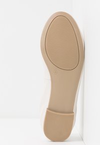 Beige shoe with rubber sole, rounded toe, and smooth leather upper. Size marked 37; textured bottom for traction.