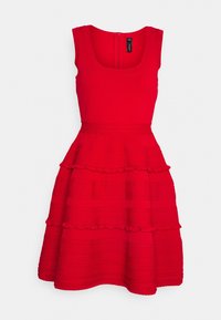 Robe rouge sans manches avec un décolleté carré, un corsage texturé et des détails de jupe à volants superposés. Fermeture éclair au dos.