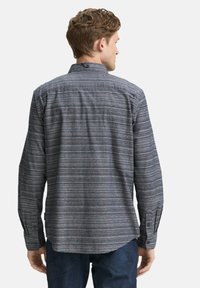 Herren Langarmhemd aus dunkelblauem Stoff mit horizontalen grauen und roten Streifen. Verfügt über einen Kentkragen und knöpfbare Manschetten.