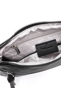 Interno di una borsa in pelle nera texture, con fodera grigia chiara, dotata di una tasca con zip e un'etichetta del marchio. Hardware della cerniera in argento.
