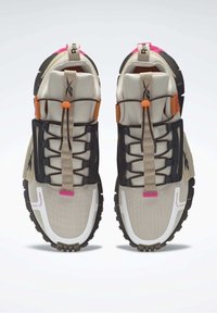 Par de zapatillas deportivas Reebok en beige, negro y rosa con suelas gruesas y cierre de cordones, vistas desde arriba sobre un fondo blanco.