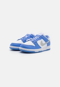 Kék bőr sportcipők fehér orr résszel, világoskék részletekkel és szürke Nike logóval. Texturált felület, az elején perforációkkal.
