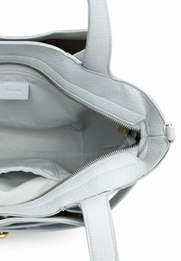 Světle šedá kožená taška typu tote se zipem na vrchu, hladou vnitřní podšívkou a malou kapsou. Má dvě rukojeti a kovové doplňky.