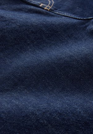 Mørkeblå denimstof med en let glans, der har en glat tekstur og subtile variationer i farve og mønster, hvilket viser en tæt vævning.