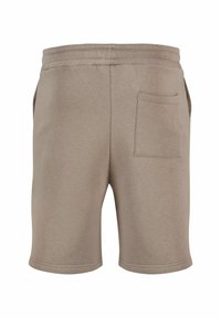 Beige bomullsshorts med elastisk livlinje, som har en enkelt baklomme og en jevn tekstur. Kantene er rene og enkle.