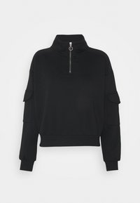 Svart tröja med hög krage och kvartslång dragkedja framtill. Har långa ärmar och två sidfickor på armarna. Mjuk textur.