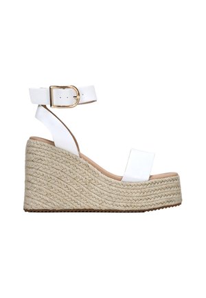 Sandalia de cuña de cuero blanco con plataforma de yute trenzado, punta abierta y correa al tobillo que presenta una hebilla dorada y textura suave.