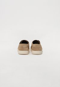 Pantofi din suede bej cu profil jos, vârf rotund și talpă din cauciuc alb. Două accente mici pe toc adaugă detalii design-ului.