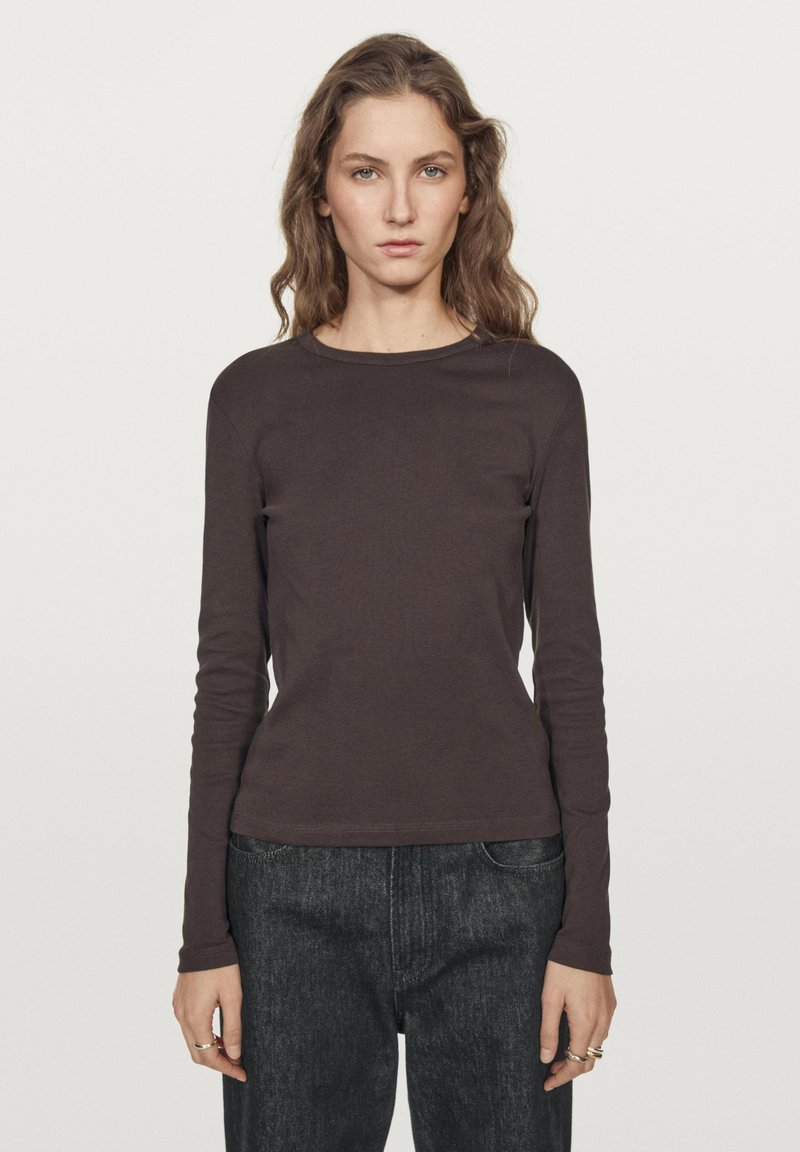 Langærmet brun skjorte lavet af blødt stof med rund halsudskæring. Tæt pasform, glat struktur, ensfarvet design, sammen med mørke jeans.