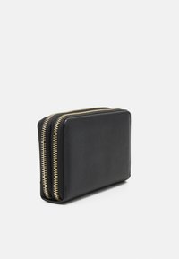 Svart skinnlommebok med teksturert overflate, med to glidelåslommer med gullfarget detaljer. Rektangulær form, kompakt design.