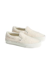 Bílé texturované slip-on boty se měkkým chlupatým materiálem, gumovou podrážkou a kontrastním bílým šitím. Označení loga na boku.