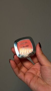 L'Oréal Le Blush i en fyrkantig ask, med en gradient i persika-rosa nyans, har ett reflekterande silverfodral och präglat varumärkesnamn.