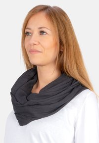 Schwarzer leichter Infinity-Schal aus gekrepptem Stoff, mit weicher Textur und geschichtetem Design, um den Hals getragen.