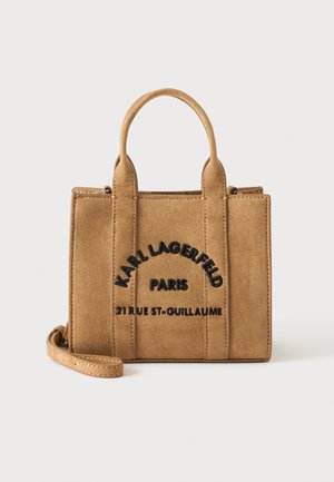 Pruun sametist ristkülikukujuline käekott kahe ülemise sangaga, must tikandiga tekst "Karl Lagerfeld Paris 21 Rue St-Guillaume," ja eemaldatav rihm.