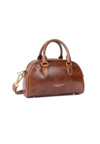 Sac à main en cuir marron avec une forme arrondie, des poignées doubles en haut et une bandoulière amovible. Il dispose de quincaillerie dorée et d'un branding subtil.