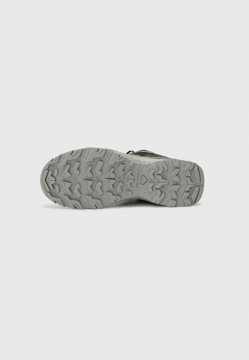Graue Außensohle von Schuhen mit einem strukturierten Profil, das robuste Traktionsdetails und ein langlebiges Design für verbesserten Grip aufweist.