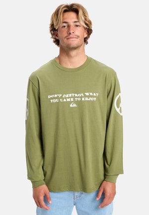 Olive green long-sleeve t-shirt made of cotton, featuring white text that reads "DON'T DESTROY WHAT YOU CAME TO ENJOY" and logo on sleeve.