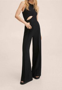 Zwarte jumpsuit met een mouwloos ontwerp, voorzien van een uitsnijding en wijde pijpen, gemaakt van een gladde, lichte stof.