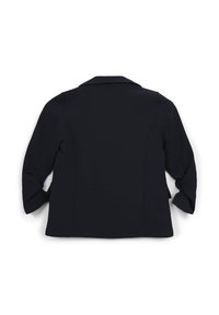 Blazer nero con una silhouette sartoriale, maniche lunghe arrotolate sui polsini e colletto classico; tessuto liscio senza fantasie.