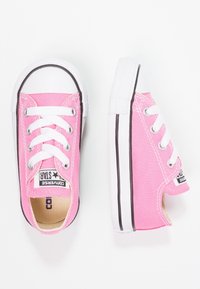 Sneakers in tela rosa con lacci bianchi e suole in gomma. Decorati con strisce nere e un'etichetta con logo. Design con punta arrotondata e modello basso.