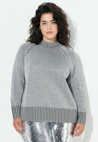 Maglione grigio lavorato a maglia con un alto colletto a coste, maniche a raglan e orlo a coste striato. Il tessuto ha una consistenza morbida e una vestibilità casual.