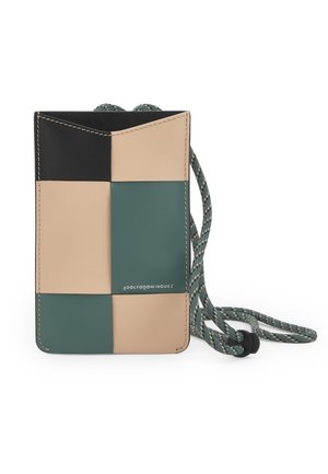 Petit sac bandoulière rectangulaire avec des panneaux patchwork en noir, beige et vert, doté d'une sangle à cordon vert à motif.