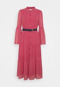 Robe midi rouge à motif blanc discret, manches longues évasées, boutonnée sur le devant, et ceinture noire avec boucle dorée à la taille.