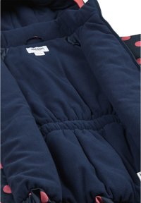 Giacca in pile della marina con pois rosa, vita elastica, chiusura con zip e etichetta interna. Texture morbida e dettagli a contrasto.