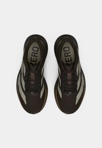 Μαύρα αθλητικά παπούτσια με γκρίζες λεπτομέρειες, υφασμάτινο επάνω μέρος, στρογγυλεμένη μύτη και σχέδιο με κορδόνια. Διαθέτουν έντονη ένδειξη "4D ZERO" στην εσωτερική σόλα.