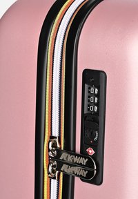 Roze harde koffer met een glanzende afwerking, voorzien van een zwarte ritssluiting, kleurrijke gestreepte accenten en een combinatieslot. K-Way branding op de ritsen.