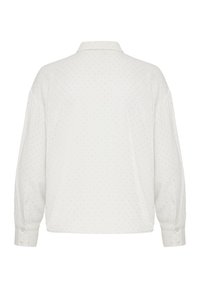 Hvid langærmet skjorte med krave, der har et subtilt prikket mønster og manchetter med knapper. Materialet virker glat og let.