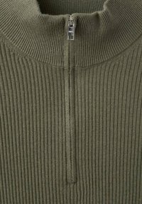 Jersey verde acanalado con cuello alto y cierre de cremallera de un cuarto. Textura suave con sensación ligera, adecuado para usar en capas.