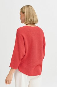 Pull en tricot rouge avec une coupe décontractée, doté d'un col rond et de manches trois-quarts. Motif texturé et ourlet uni.