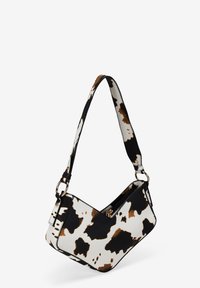 Bolso de mano con estampado de vaca y forma estructurada, hecho de material sintético. Presenta una correa negra en contraste y detalles en dorado.