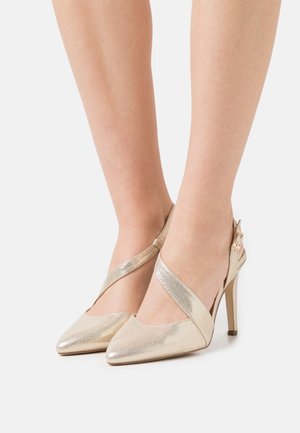 Gold slingback heels with a pointed toe, featuring a crisscross ankle strap and a thin stiletto heel, made of metallic textured material.