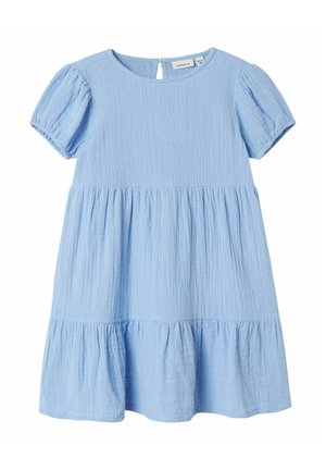Robe en coton bleu clair avec un col rond, des manches courtes bouffantes et une jupe à volants. Dispose d'une fermeture à boutons au dos et d'un tissu texturé.